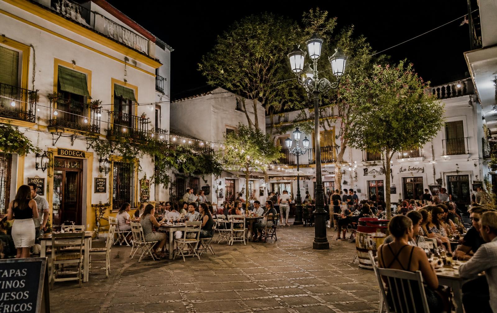 Tapas terraces filling a lively town square on a summer night