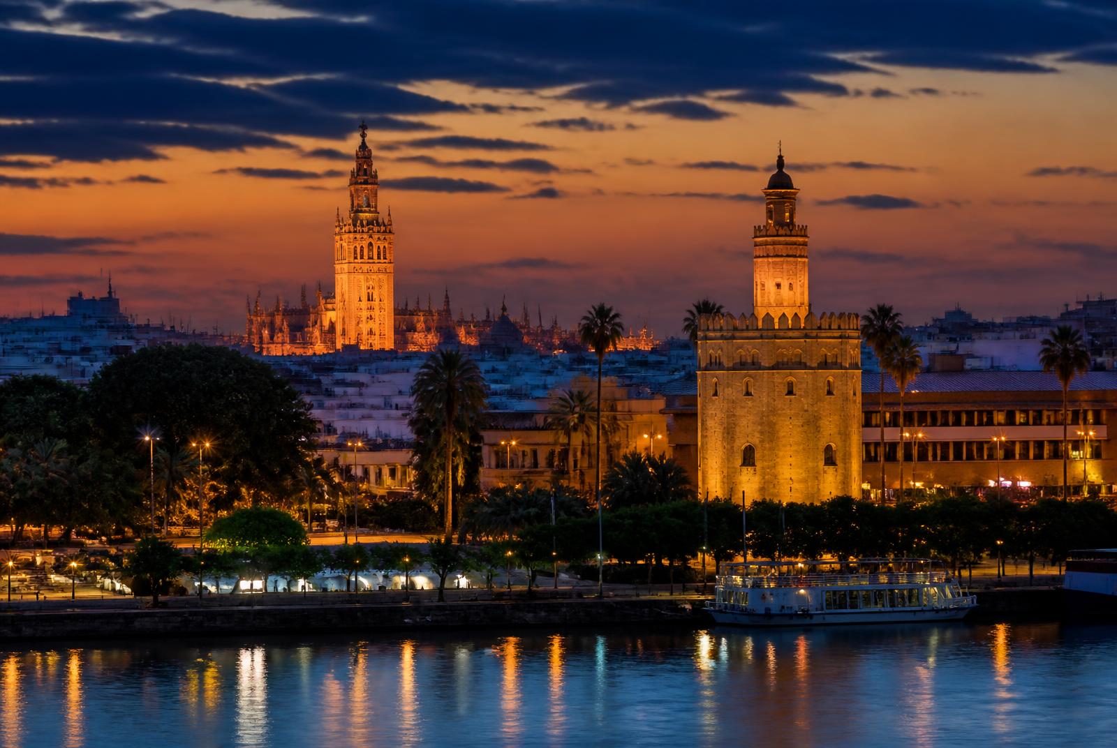 Seville skyline at dusk with the Guadalquivir river, Torre del Oro and the Giralda